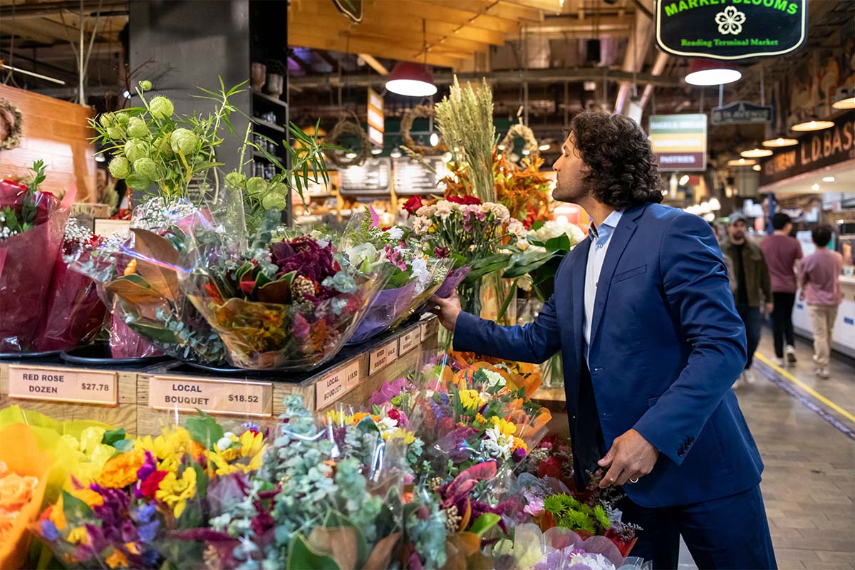 Person in grocery store shopping for flowers.