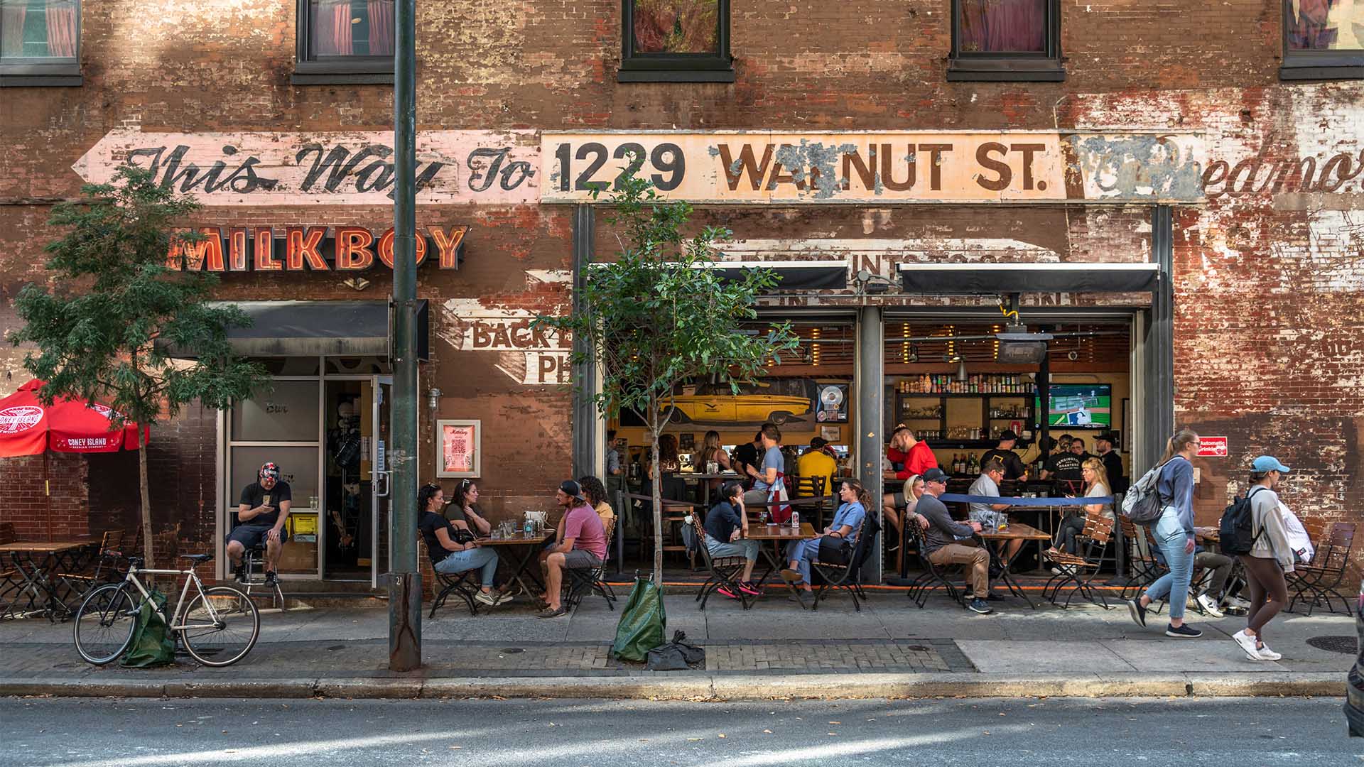 Milkboy bar with garage doors and outdoor dining.