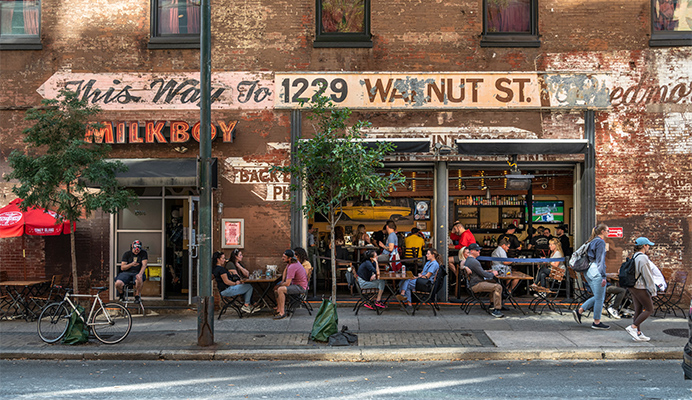 Milkboy bar with garage doors and outdoor dining.