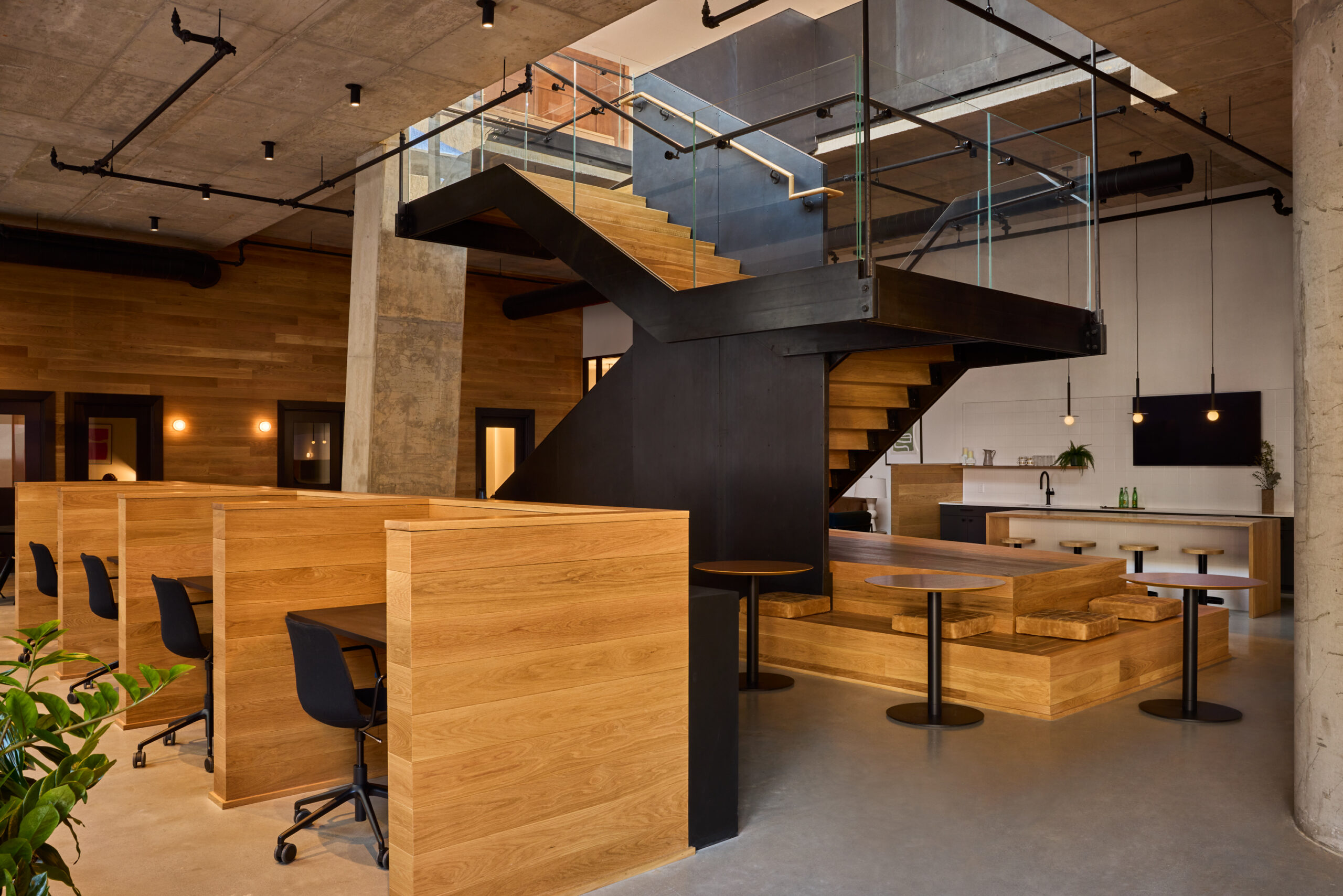 Co working space at Jessup House Apartments in Philadelphia, featuring wooden cubicles with desks and chairs.