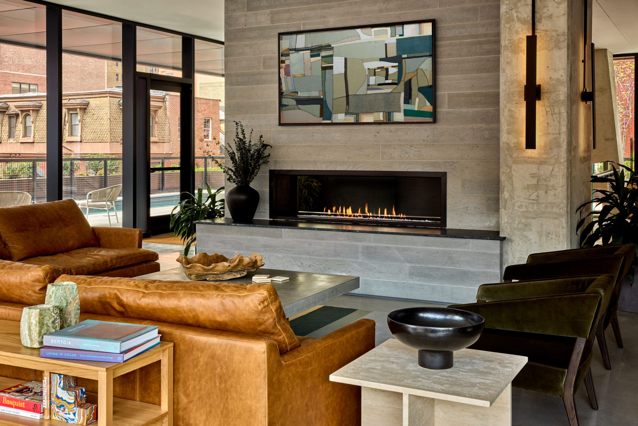 Resident lounge at Jessup House Apartments in Philadelphia, featuring leather couches and a fireplace.