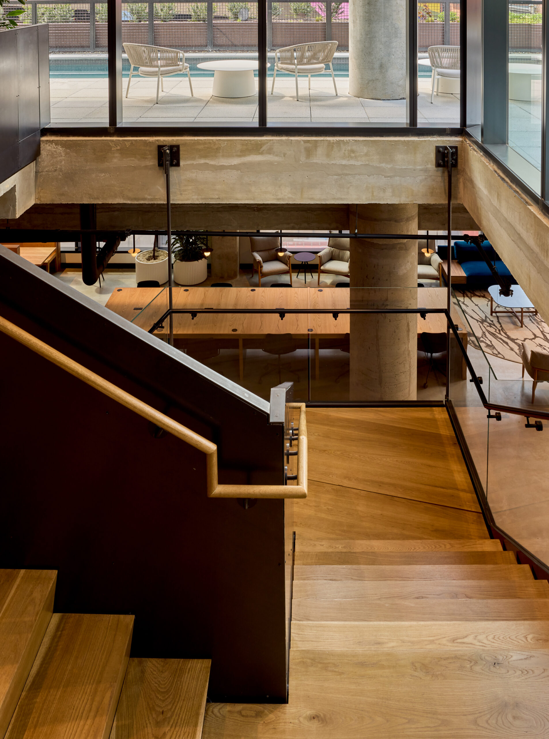 The stairway at Jessup House Apartments in Philadelphia, featuring wood grain flooring and a view of the lounge.