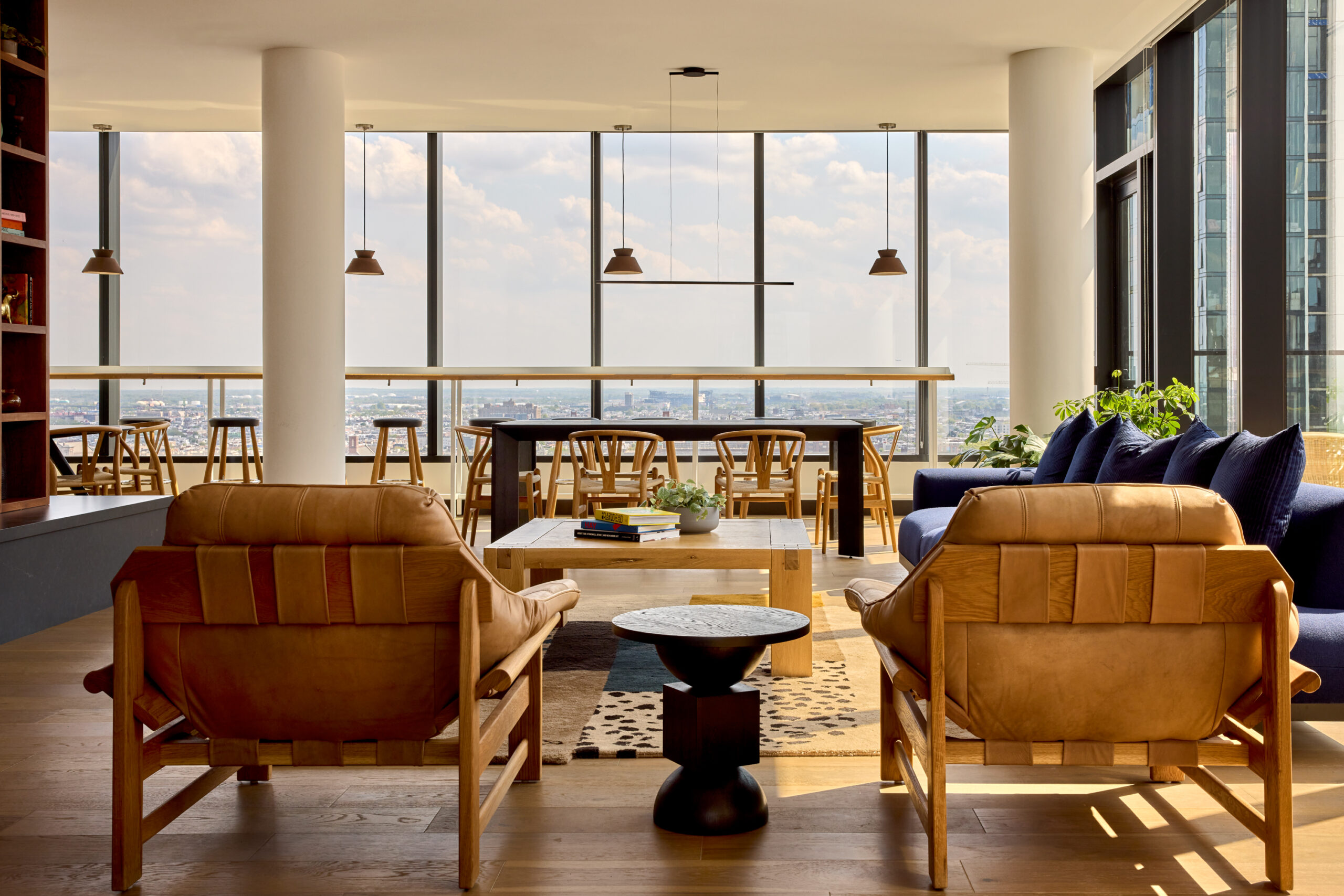 Resident lounge at Jessup House Apartments in Philadelphia, featuring wood grain flooring and blue couches.